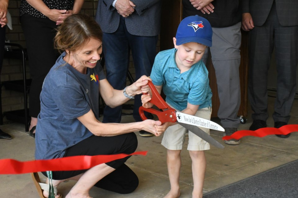 Wanda Peakman, co-ordinator of the Moose Jaw Early Years Family Resource Centre, helps Max Adrian, 5, cut the ribbon during the official grand opening ceremony on June 21. Photo by Jason G. Antonio 