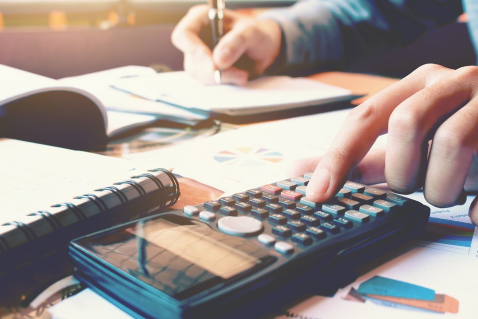 woman using calculator paying bills shutterstock