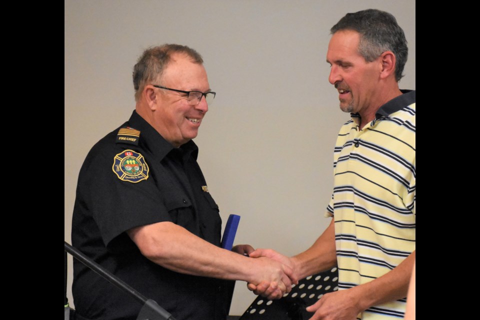 Caronport fire Chief Rod Appleby shakes hands with Caronport Mayor Daniel Buck after receiving the Governor General’s Fire Services Exemplary Service Medal and two bars on Oct. 19 to honour his 40 years of service. Photo by Jason G. Antonio