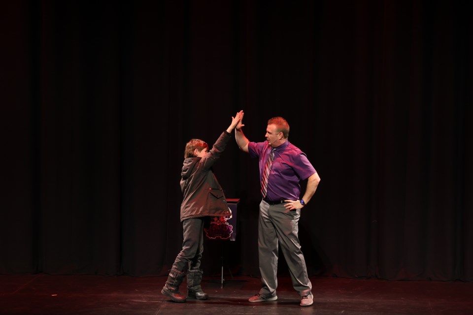 A boy from the audience gives a high-five to Trevor Watters