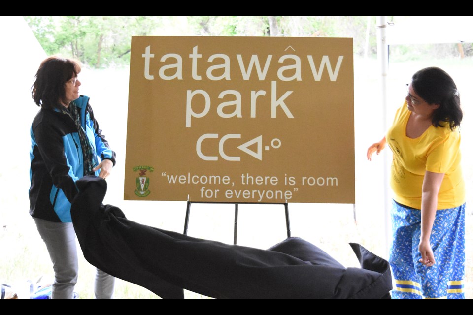 South Hill Community Association chair Crystal Froese and Wakamow Aboriginal Community Association chair Lori Deets unveil the new Tatawaw Park sign.