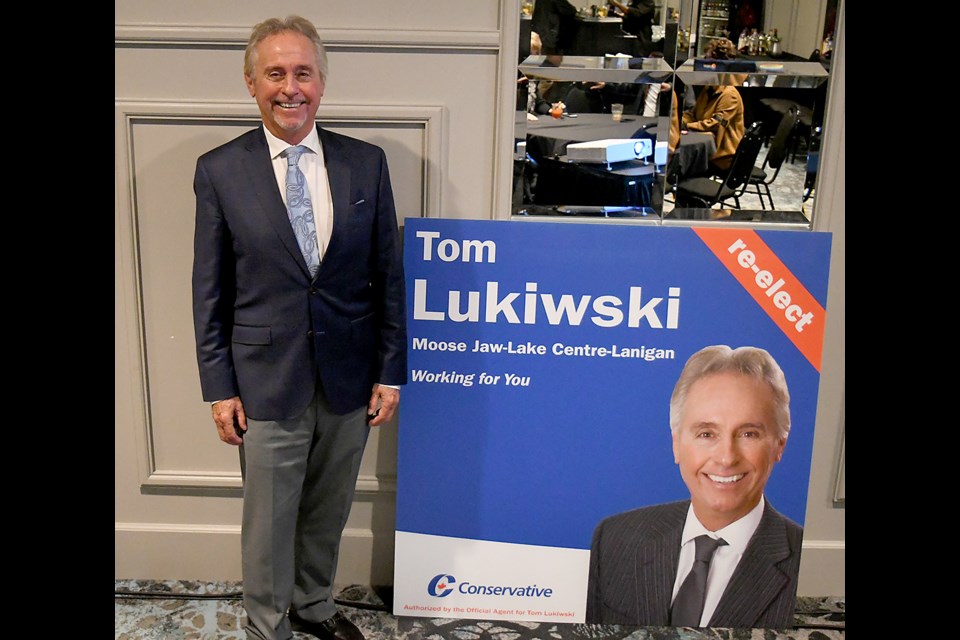 Tom Lukiwski poses with a campaign sign after winning the Moose Jaw – Lake Centre – Lanigan riding.