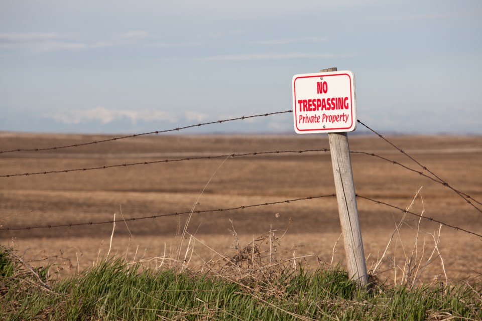 No trespassing sign on rural property fence