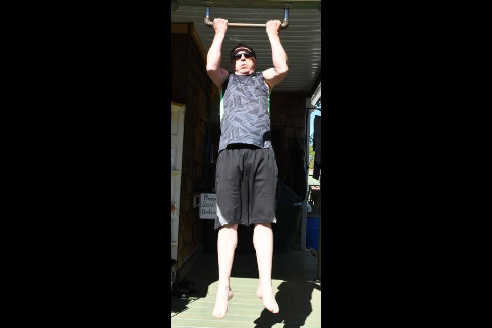 Dale Roach performs pullups from a makeshift pullup bar that he constructed in his backyard, as part of a homemade gym to help manage his COPD illness. Photo by Jason G. Antonio 