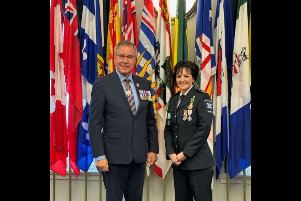 Angela Sereda receives the Protective Services Medal from Lt.-Gov. Russ Mirasty