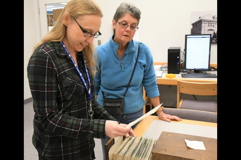 Reference technician Stephanie Jeanes and visitor Nancy Ayers look through some of the military enlistment records from the First World War in the Moose Jaw Public Library’s archives room. Photo by Jason G. Antonio