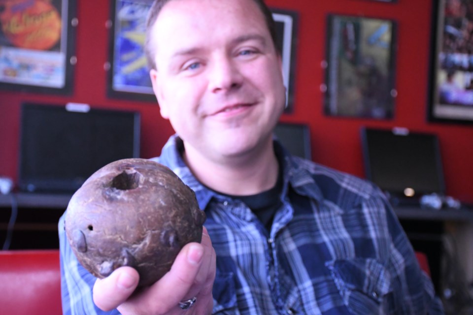 Joe Dueck, founder of Joe’s Place Youth Centre, holds up an ancient mace head he found while digging a trench in Bosnia during a tour with the Canadian army in 1994. Photo by Jason G. Antonio