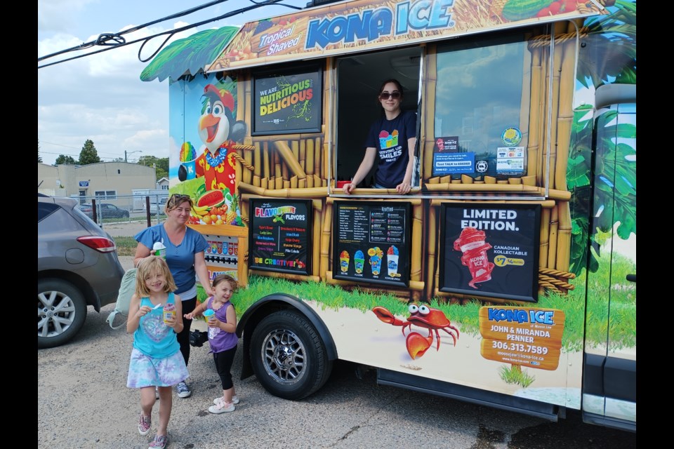 Patrons enjoy a cold treat from Kona Ice, just one of the vendors who attended the anniversary event on Monday. 