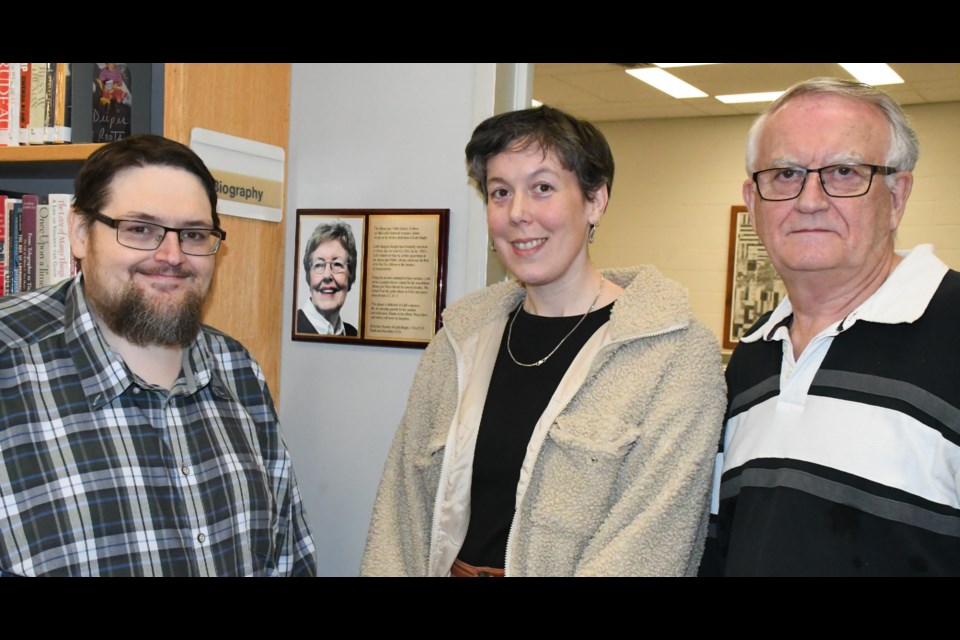 Scott Hellings, assistant head librarian Shevaun Ruby and Larry Hellings stand near the new plaque, after an event that officially unveiled the dedication. Photo by Jason G. Antonio