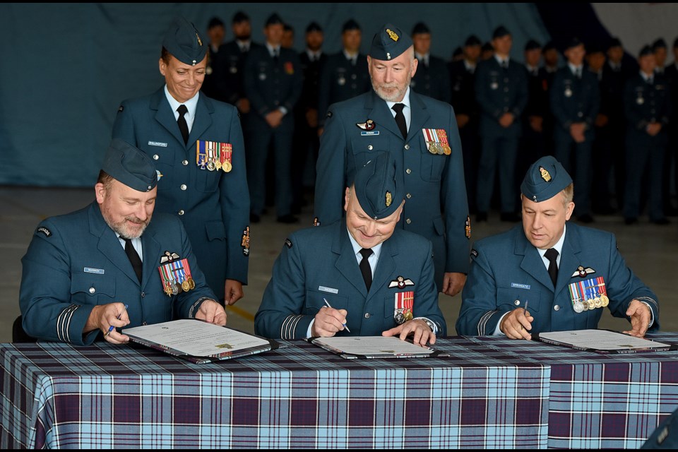 Outgoing Big 2 commander Lt. Col. Jody McKinnon, 15 Wing commander Col. Ron Walker and new Big 2 commander Lt. Col. Blair Springate sign the change of command orders as 15 Wing CWO Marlene Shillingford and Big 2 CWO Bill Doman look on.