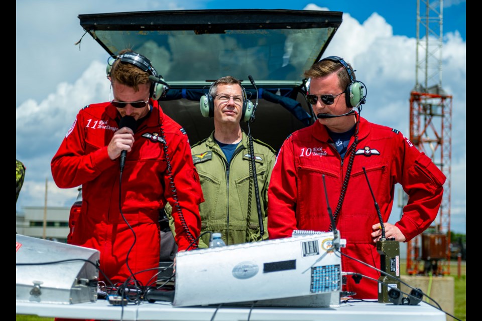 1 Canadian Air Division Commander Major-General Eric Kenny (middle) listens in on the Canadian Forces' Snowbirds pilots while Captain Rich MacDougal and Captain Erik Temple of the Snowbirds introduce the team during the 2022 Acceptance Show on 9 June, 2022 at 15 Wing Moose Jaw, Saskatchewan.