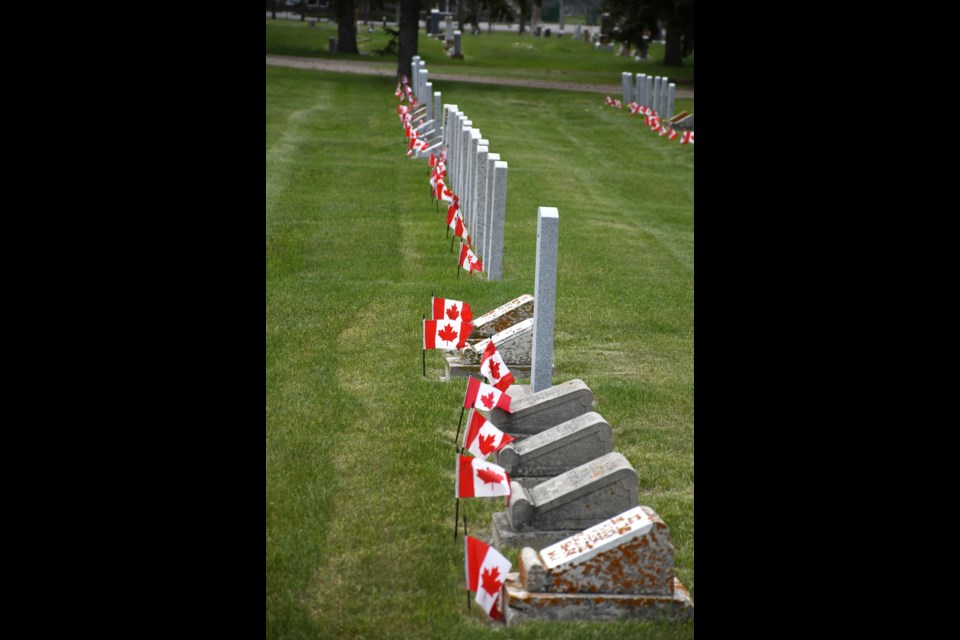 Headstones of fallen soldiers are decorated with Canadian flags in Rosedale Cemetery.