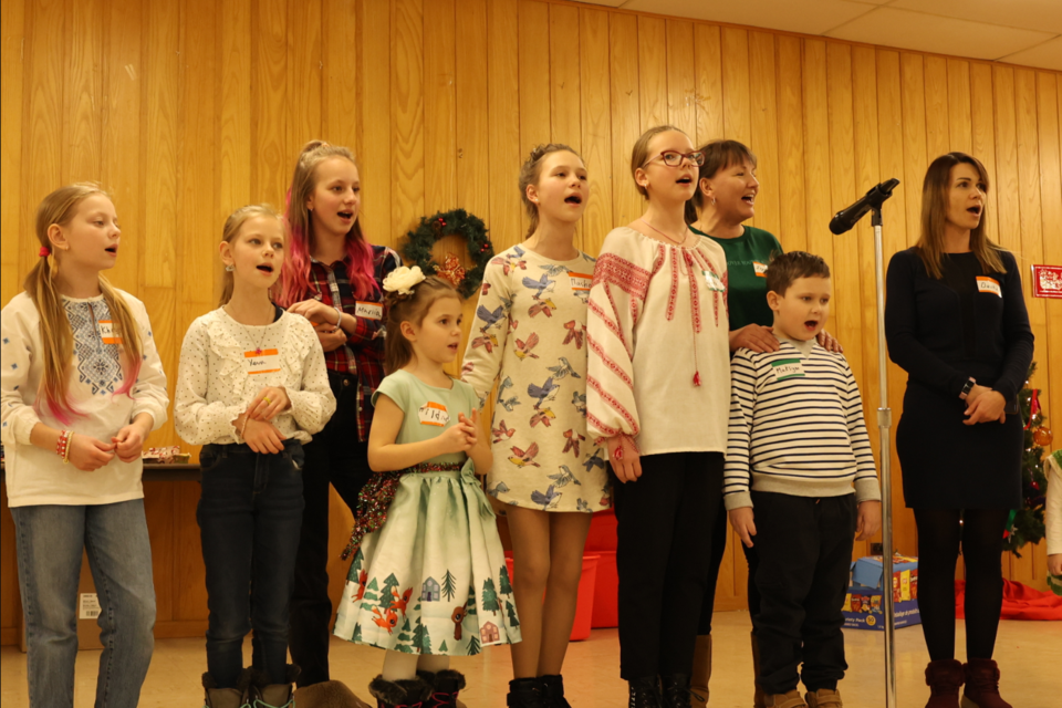 Ukrainian children sing traditional songs during a supper