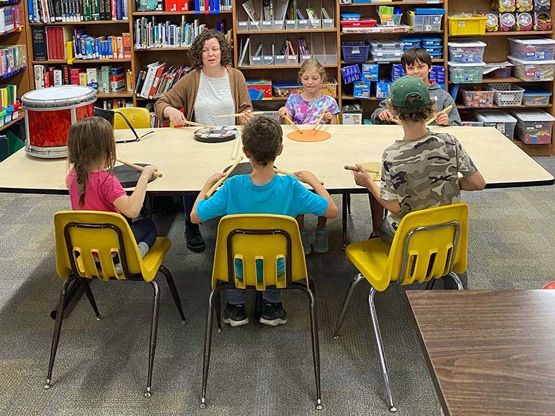 Michelle Carline, a community bagpiper (adult, facing camera) teaches youths to play the drums, during an open house in September. Photo courtesy Pipes/Drums.com