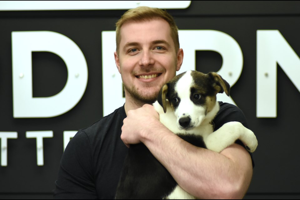 Bobby Baiton, a sleep consultant at Modern Mattress in Moose Jaw, greets one of the puppies visiting the retailer from Running Wild Rescue on March 1.