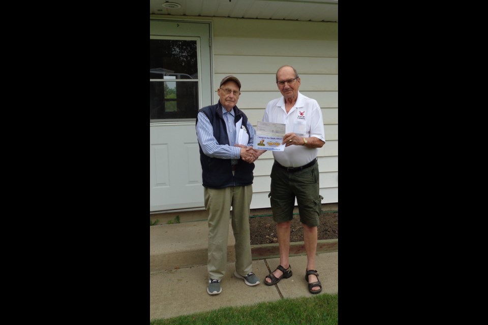 Past President Chris Svab presents the Early Bird prize of $5,000 to John Smallwood of Moose Jaw.           