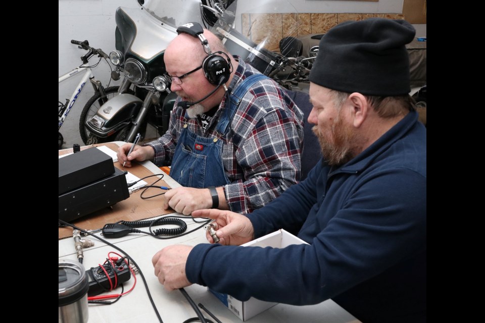 Moose Jaw Amateur Radio Club members Frank Lloyd (foreground) and Dave communicate with someone somewhere in the world using a ham radio. Photo courtesy Facebook