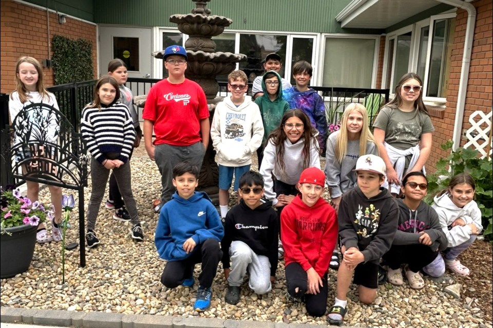 Grade 5 students from St. Michael School pose in the Serenity Garden at Pioneer Lodge after placing their hand-painted rocks as part of a Heartland Hospice beautification project.