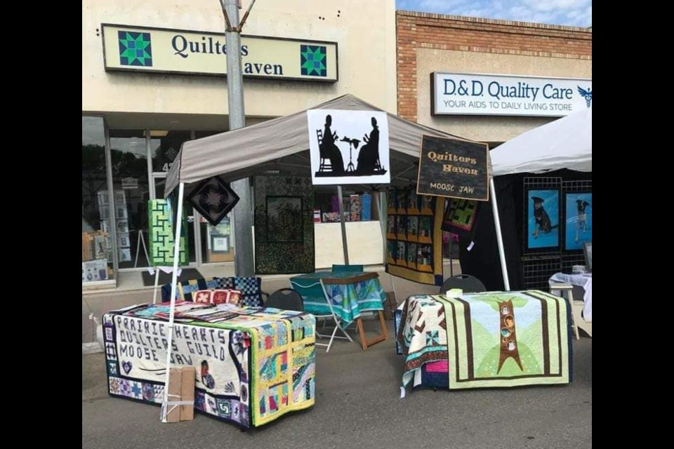 The Prairie Hearts Quilters' table at the Moose Jaw Sidewalk Days Festival in July