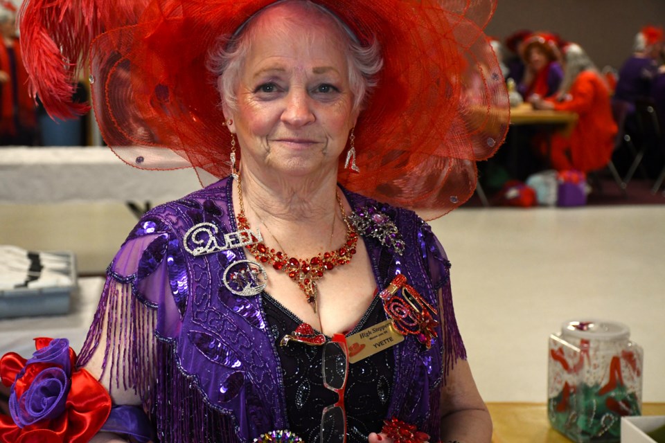 Yvette Gardner, Queen of the High Steppers chapter of the Red Hat Society, dons one of her signature red hats during a group event in May.