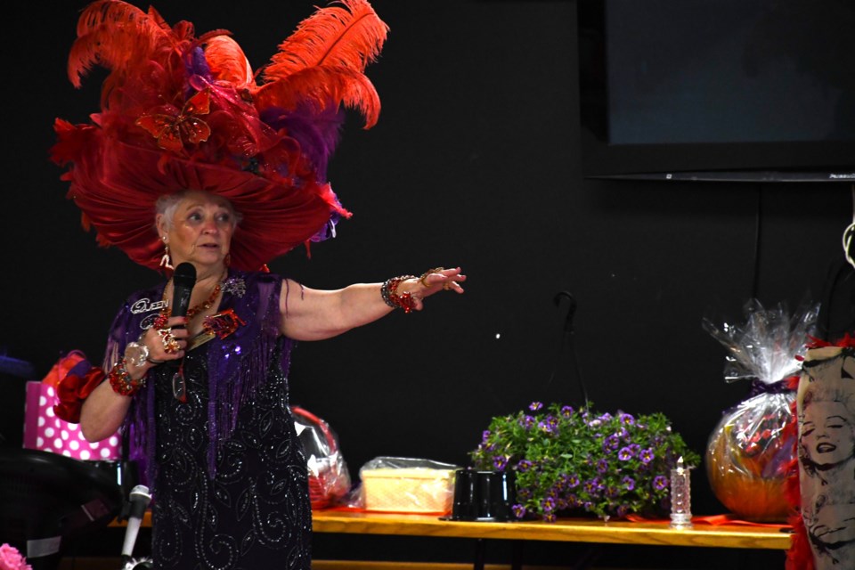 Yvette Gardner, Queen of the High Steppers chapter of the Red Hat Society, dons one of her signature red hats during a group event in May.