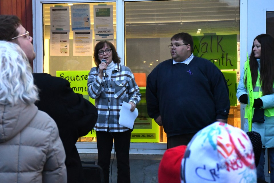 Della Ferguson (left, with microphone) and Max Eckstein (right) share a few words before the 2025 “Walk for Warmth” on March 13.