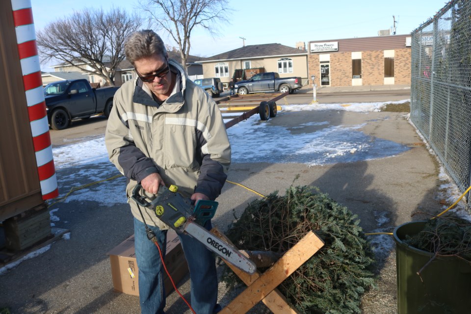 Customer Craig Snyder trims down his tree at the Rotary Club’s Christmas tree lot on Thursday. Photo by Shawn Slaght