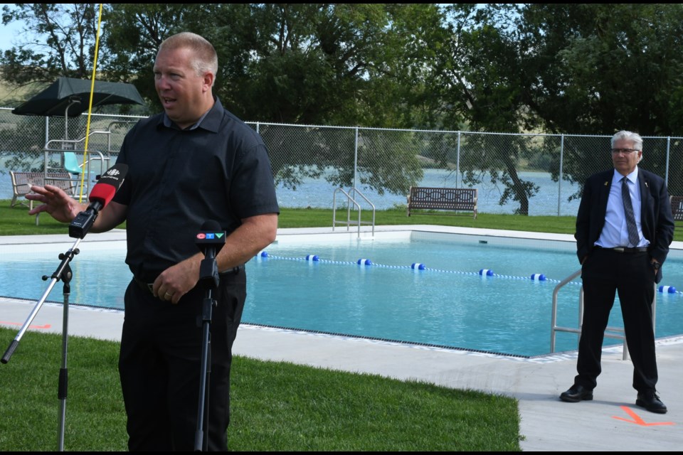 MLA Gene Makowsky, minister of parks, culture and sport, speaks during the opening of the new Buffalo Pound Provincial Park pool on July 17, while MLA Warren Michelson looks on. Photo by Jason G. Antonio 