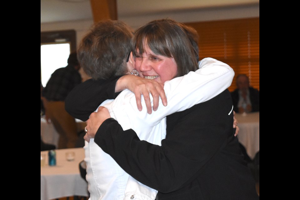Wakamow Valley CEO Margaret Moran hugs a well-wisher after arriving for her retirement surprise party.