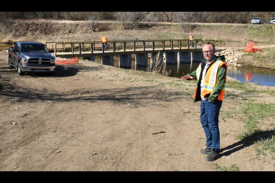 Todd Johnson, general manager of Wakamow Valley Authority, talks about the project to install a new walking bridge near Fourth Avenue South. Photo by Jason G. Antonio