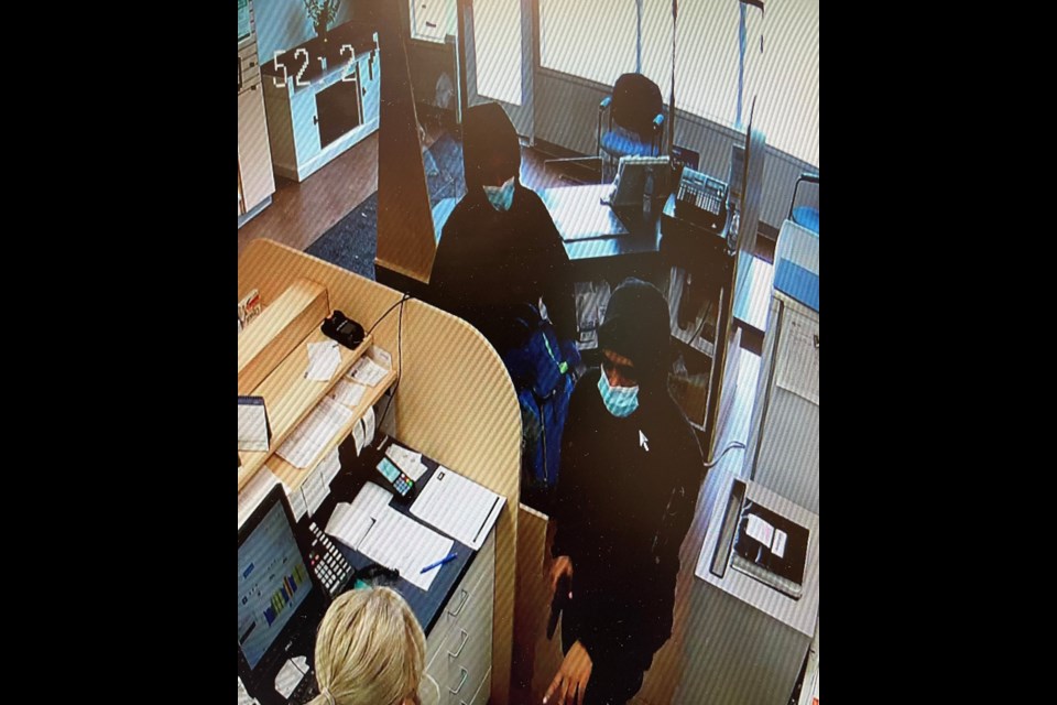 A photo from a security camera shows two people allegedly holding up a business on South Hill with a handgun. Photo courtesy Moose Jaw Police Service