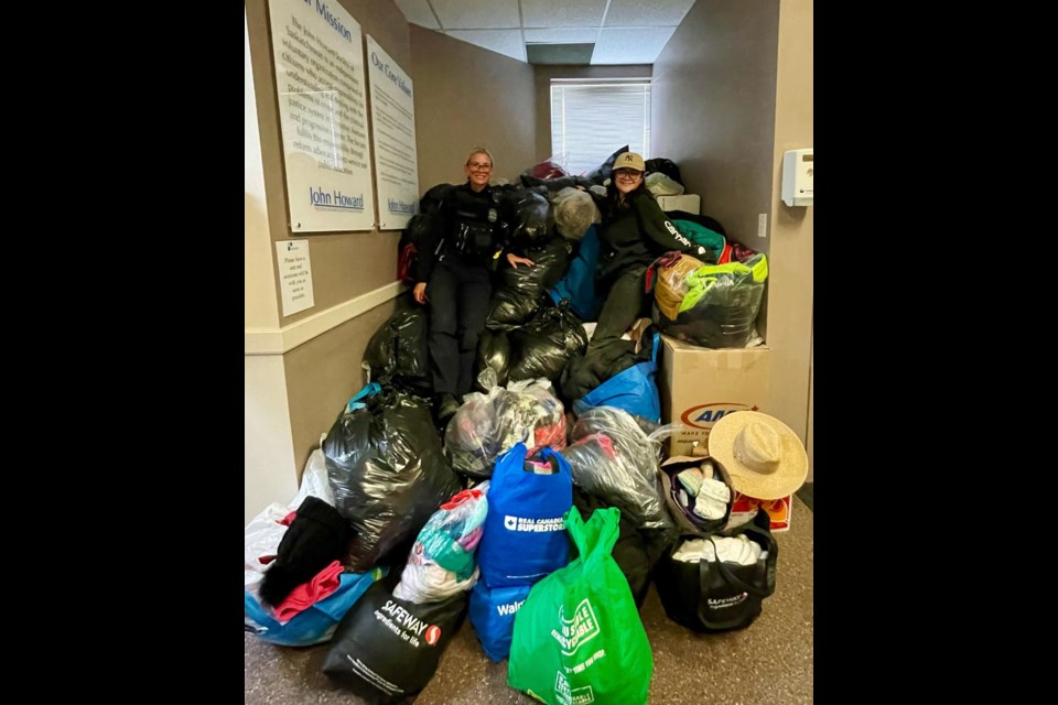 Constable Jayme Hoffman, left, dropping off the full 'mountain' of warm clothing gifted to the Moose Jaw John Howard Society