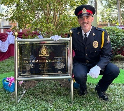 Const. Chris Flanagan poses with a plaque dedicated to his father, Cpl. Derek Flanagan, an RCMP officer who died in Thailand in February 1989 during an undercover mission. Photo submitted