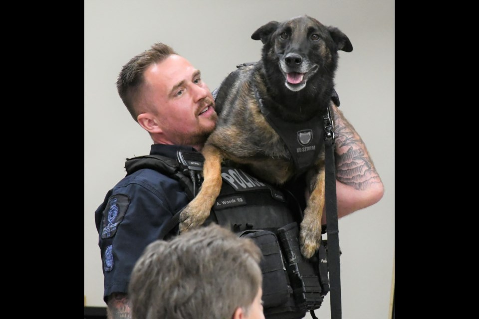 Const. Aaron Woods gives a lift to his furry partner, True, during a discussion about the police service's K-9 Unit. Photo by Jason G. Antonio 