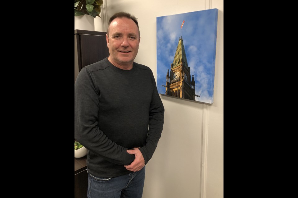 Fraser Tolmie, the MP for Moose Jaw-Lake Centre-Lanigan, poses in his office next to a picture of the Peace Tower in Ottawa. Photo by Jason G. Antonio