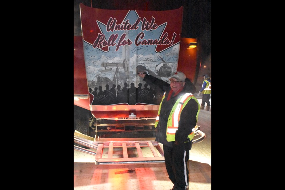 Moose Jaw yellow vest organizer Al Church signs the cab of the United We Roll convoy's fire truck.