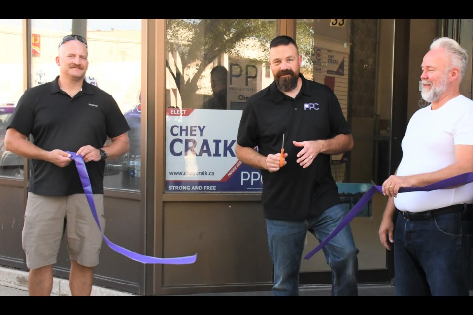 Chey Craik (centre), candidate for the People's Party of Canada, cuts a ribbon to officially open his campaign office at 33 High Street West, on Aug. 30. Photo by Jason G. Antonio