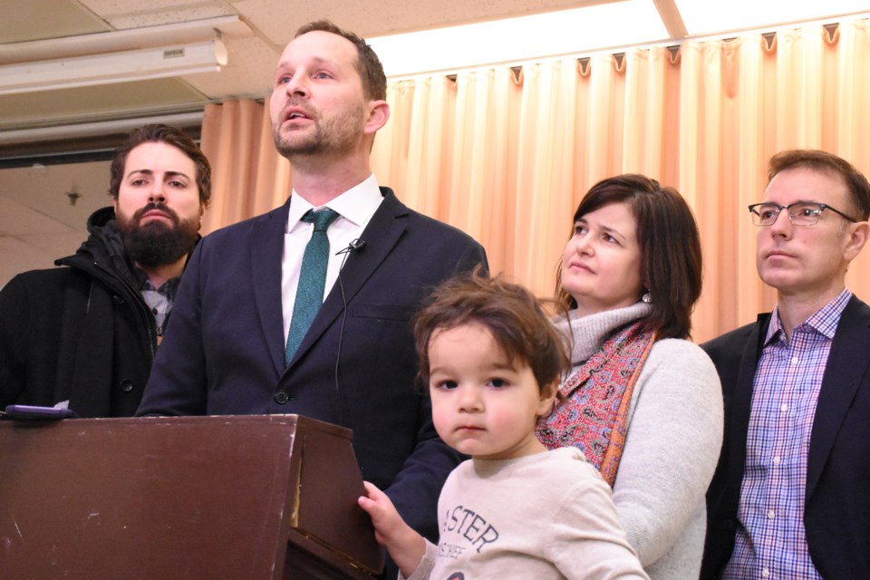 Little Gus Meili hangs around with his dad, Saskatchewan NDP leader Ryan Meili, during a media scrum at the Timothy Eaton Centre on Feb. 19. Standing beside Meili are welder/boilermaker Shawn Johnson and MLAs Carla Beck and Yens Pederson. Photo by Jason G. Antonio  
