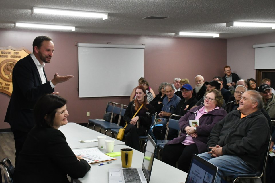 Ryan Meili, leader of the Saskatchewan NDP (left, standing), and fellow MLA Carla Beck speak to residents about the importance of Saskatchewan’s education system during a town hall in Moose Jaw on Oct. 17. Photo by Jason G. Antonio