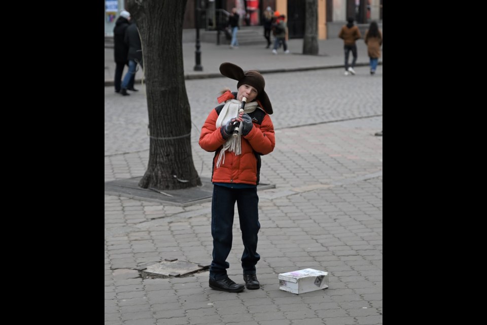 A child out busking with his recorder on Deribasovskaya Street