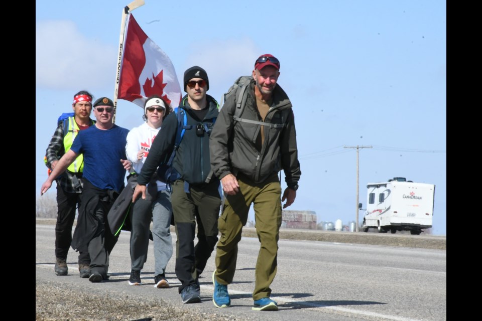Military veteran James Topp (front) leads a small squad of people during a march on Highway 1 outside Moose Jaw. He is marching to protest the federal government's pandemic mandates. | Photo by Jason G. Antonio 