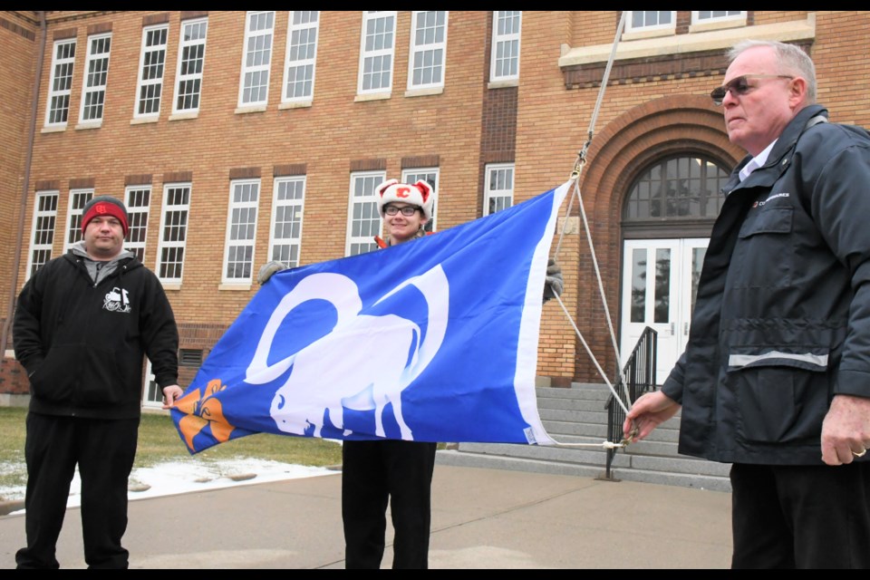 Students Pat Redwood (left) and Adam Strong and commissionaire Al Vance prepare to fly the Métis flag over the Saskatchewan Polytechnic Moose Jaw campus on Nov. 15. Photo by Jason G. Antonio 