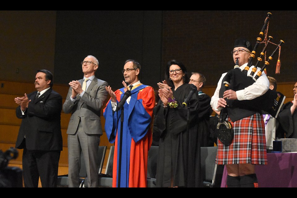 Sask Polytechnic platform guests applaud as Pat Luchenski pipes in the 2019 graduates.