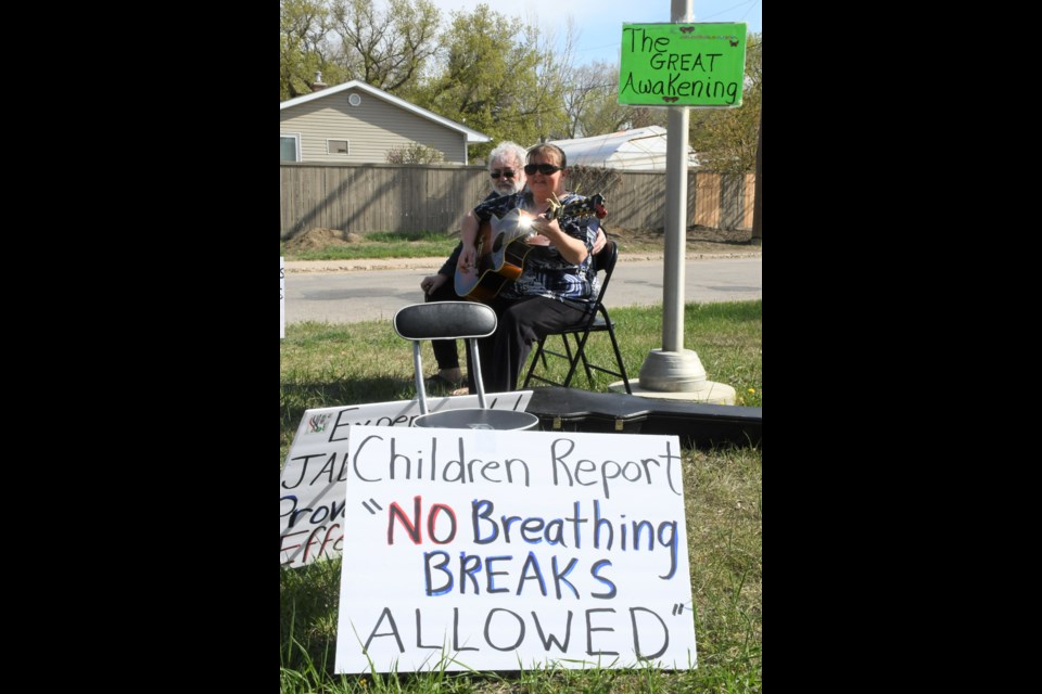 Signs surround Tannis and Ivan Brideau as they protest the continued use of masks in schools. Photo by Jason G. Antonio 
