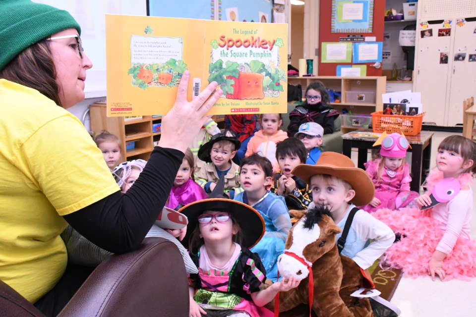 Pre-kindergarten teacher Jodi Feiffer reads a book to her class at Palliser Heights School before the start of Halloween-related activities on Oct. 31. Photo by Jason G. Antonio