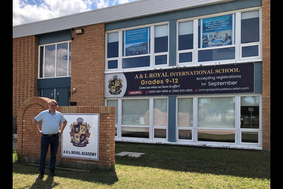 Jeff Mathieson, principal of A & L Royal International School, stands in front of the school's new sign. Photo by Jason G. Antonio