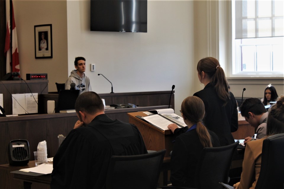 A member of the defence cross-examining a witness on the stand, who was going by the moniker Mike Bourke — for the sake of the fake incident that cited the charges.