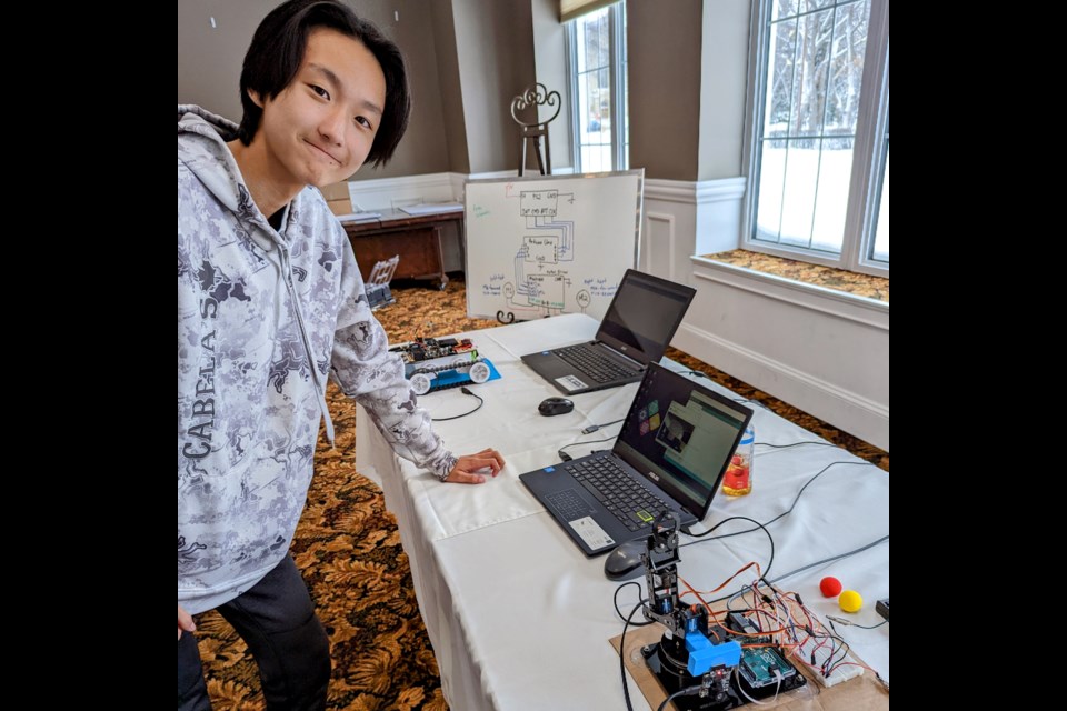 James, 13, demonstrates his robotics project