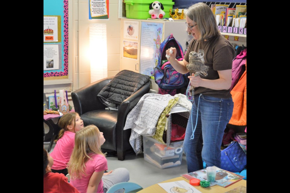 Lori Johnson, from the Saskatchewan Burrowing Owl Interpretive Centre, shows students at  Ms. Gosselin's Grade 1-2 class at Sacred Heart Community School a baby owl egg with Cricket the owl perched on her hand. (Matthew Gourlie) 