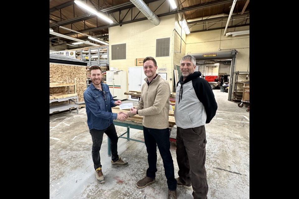 Peacock's shop teacher Joel Robinson (left) receives the donation from Alex Zwart (center) and Gordon Murdoch (right).